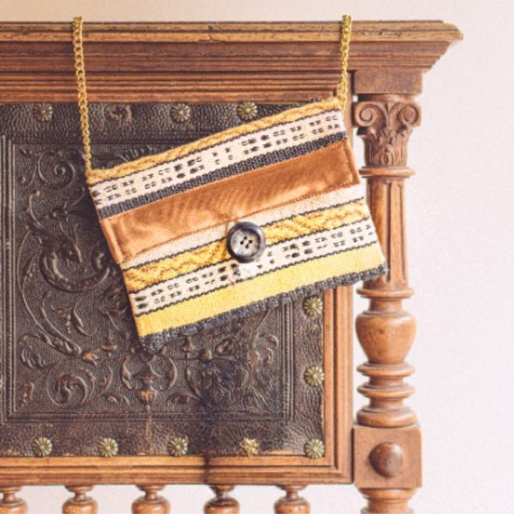 Kleine handgewebte Handtasche von Wiedengold mit reduzierter Streifenornamentik – textiler Begleiter für stilvolle Momente.