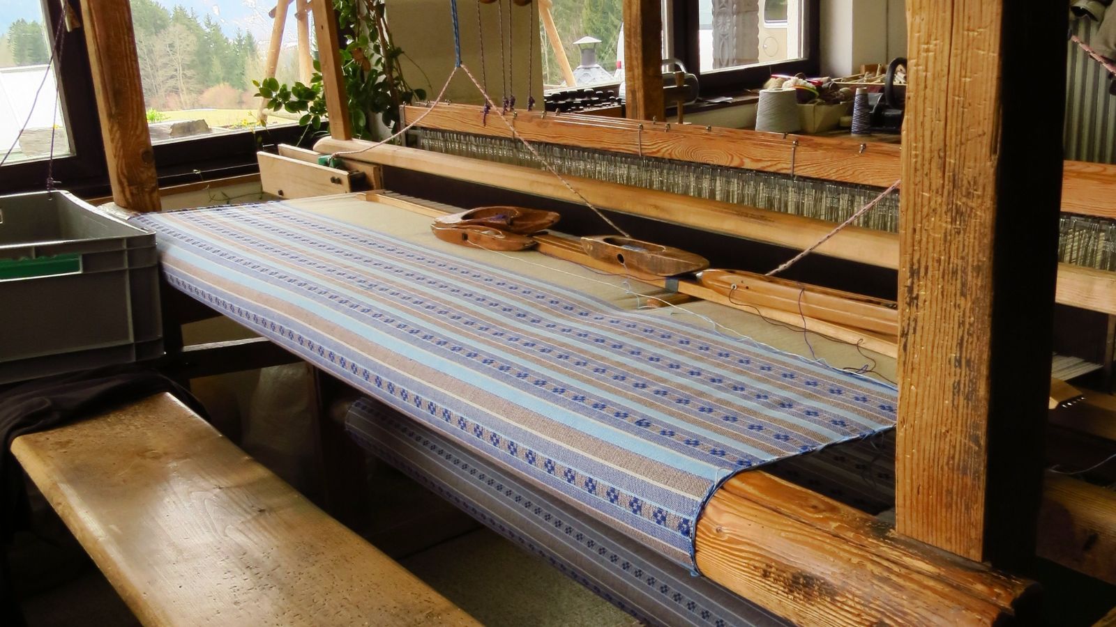 Handgewebter Möbelbezugstoff im Entstehungsprozess am Webstuhl – präzise Atelierarbeit der Handweberei Wiedengold.