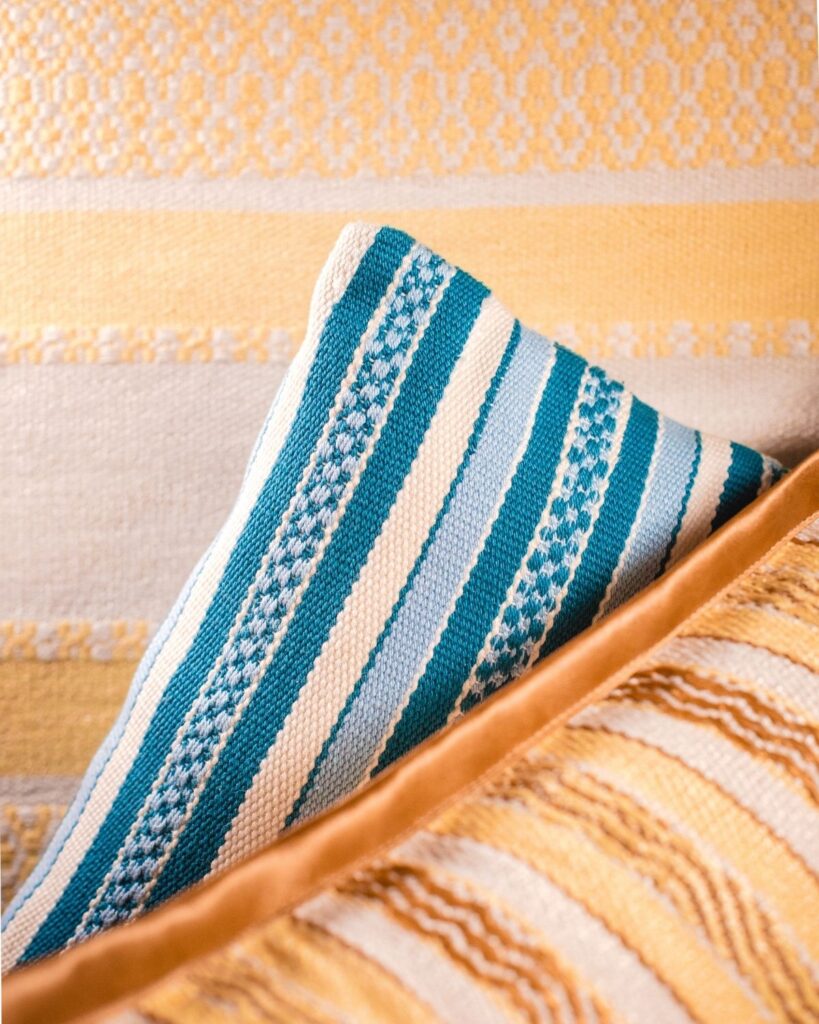 Handgewebter Tischläufer und Kissen von Wiedengold für den Sommer.