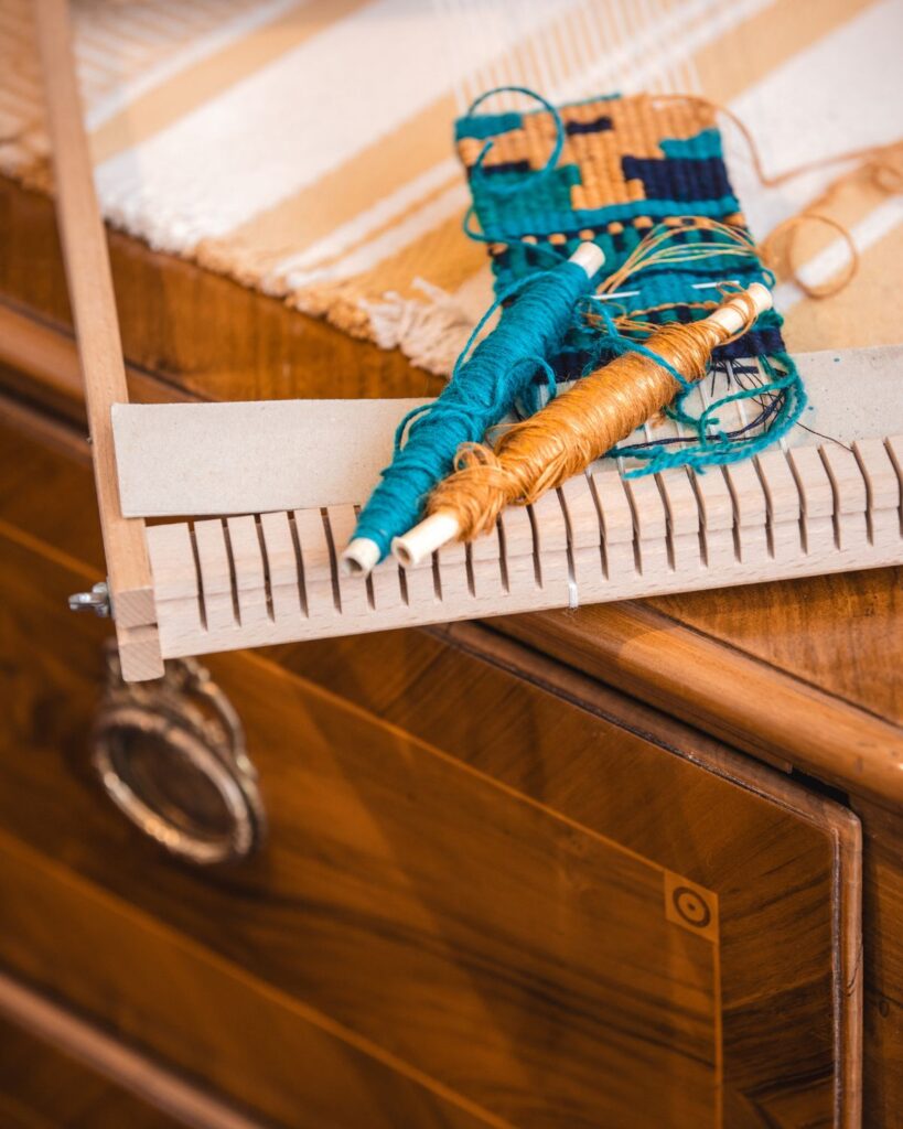 Spulen mit Garnen auf einem Webrahmen in der Handweberei Wiedengold.